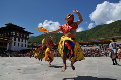 Full length of woman dancing against sky