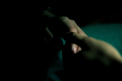 Close-up of woman hand over black background