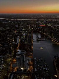 High angle view of illuminated city at sunset