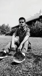 Portrait of young man sitting on field