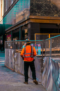 Rear view of men working on street by building