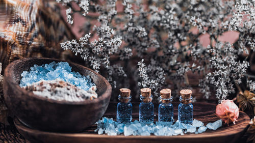 Close-up of rock salt and bottles in tray