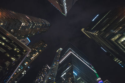 Low angle view of illuminated buildings against sky at night