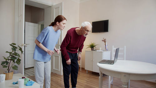 Side view of female friends with arms raised standing in bathroom