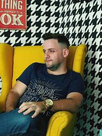 Mid adult man sitting on chair at home