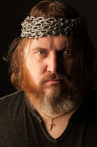 Close-up portrait of man against black background