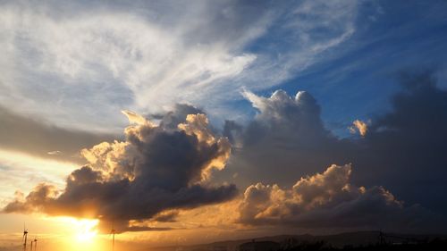 Low angle view of sunlight streaming through clouds