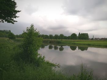 Scenic view of lake against cloudy sky