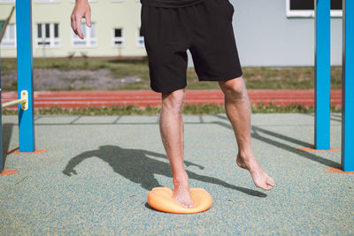 Professional athlete strengthens his ankle on a special orange air-filled lens
