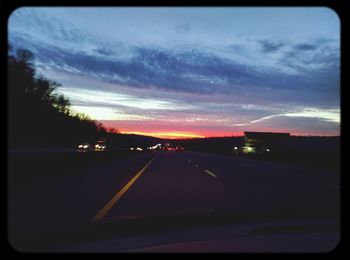 Road passing through sunset