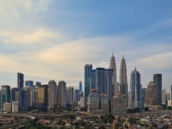 Buildings in city against cloudy sky