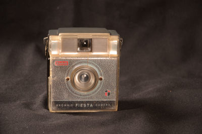 Close-up of camera on table against black background