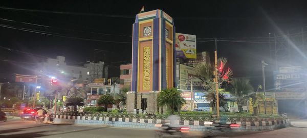 Cars on illuminated city street at night