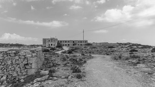 Abandoned built structure on landscape against sky