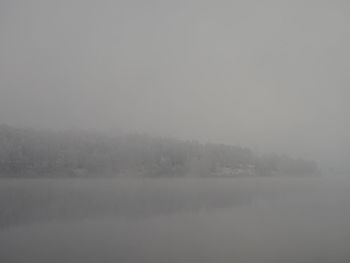 Scenic view of lake against sky during winter