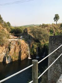 Scenic view of river by cliff against sky
