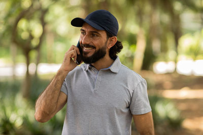 Young man at park on a beautiful sunny day with mobile phone.  working  leisure. green and nature 