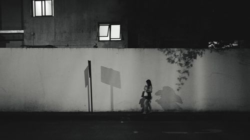 Woman in front of building at night