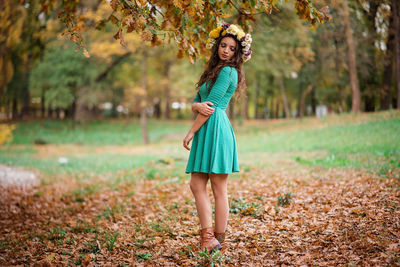 Full length portrait of young woman standing on land