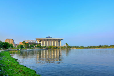 Built structure in lake against clear blue sky