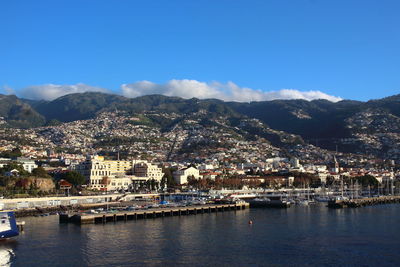 High angle view of townscape by lake against mountain