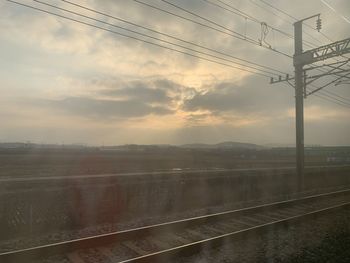 Railroad tracks against sky during sunset