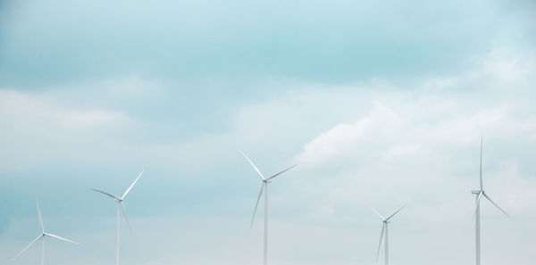 Low angle view of windmills against sky