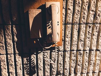 Old-fashioned telephone mounted on textured wall