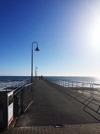 Street by sea against clear sky