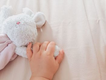 Low section of baby girl lying on bed