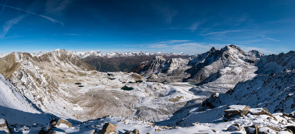 Scenic view of snowcapped mountains against blue sky