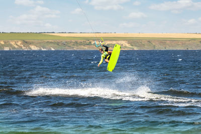 Man surfing in sea against sky