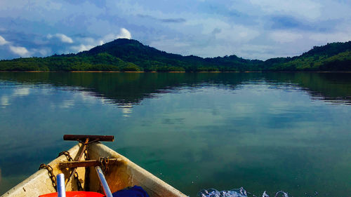 Scenic view of lake by mountain against sky