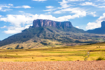 Scenic view of field and mountains against sky