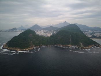Scenic view of sea and mountains against sky