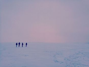 People on snow against sky during winter