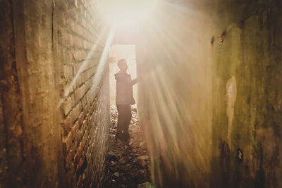 Rear view of man standing against sunlight