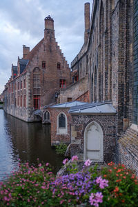 Canal amidst buildings against sky