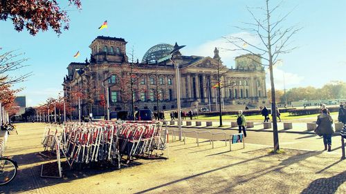 People walking in city against clear sky