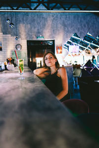 Portrait of woman sitting at bar counter