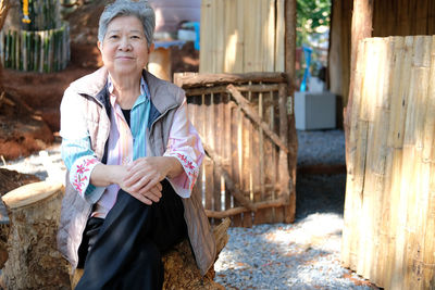 Portrait of smiling senior woman sitting outdoors