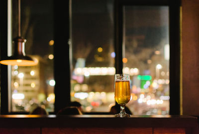 Beer in glass on table against window in bar