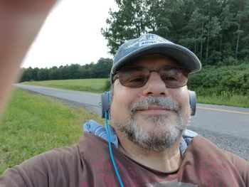 Portrait of man wearing hat against trees