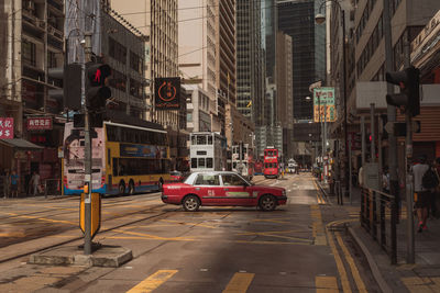 Vehicles on road against buildings in city