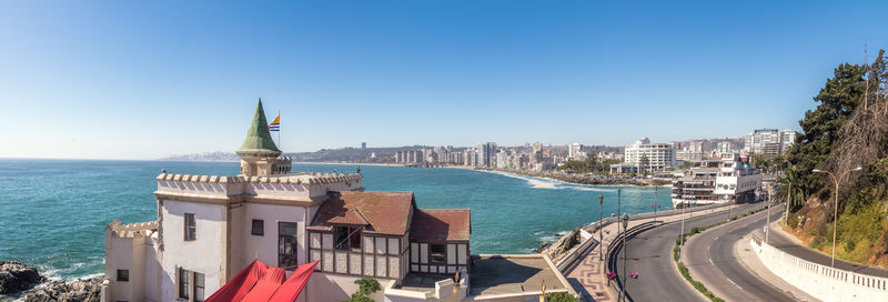 Buildings in city against clear blue sky