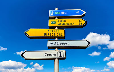 Low angle view of sign board against blue sky