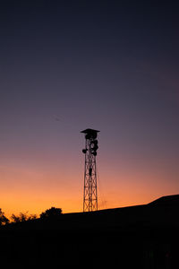 Silhouette electricity pylon against clear sky during sunset
