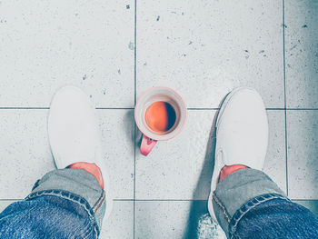 Low section of man standing on tiled floor