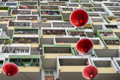 Close-up of red lanterns against apartment buildings