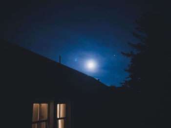 Low angle view of silhouette building against sky at night